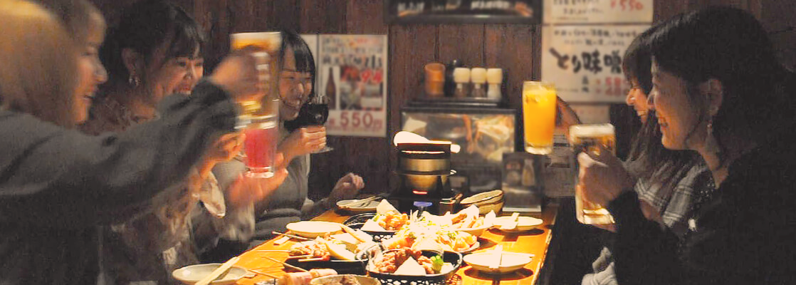 女子会で笑顔で乾杯している若い女性たち